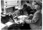 Blick in den Führerstand einer elektrischen Schnellzuglokomotive (verm. E 18/19).Die linke Hand ruht auf dem sog. Totmannkopf, heute als Sicherheitsfahrschaltung (Sifa) bezeichnet. (1937) <i>Foto: RVM</i>