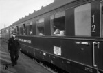 Ein Zollbeamter am Rheingold-Zug (Amsterdam CS - Chur) im Bahnhof Emmerich. (1951) <i>Foto: Slg. Eisenbahnstiftung</i>