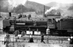 38 3794 passiert einen Bahnübergang bei Gutach im Schwarzwald. Im Vordergrund eine Hochzeitsgesellschaft, links die Braut in landesüblicher Tracht. (1937) <i>Foto: RVM</i>