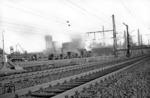 Blick auf die Anlagen der Hüttenwerke Oberhausen (HOAG). Im Werksgelände ist ein Zug mit Pfannenwagen und flüssigem Roheisen unterwegs. (15.03.1960) <i>Foto: Slg. Eisenbahnstiftung</i>