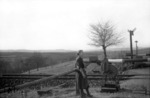 Eine Vertragsschrankenwärterin der Deutschen Bundesbahn an einer Anrufschranke bei Schwäbisch Hall-Hessental. (1955) <i>Foto: Slg. Eisenbahnstiftung</i>