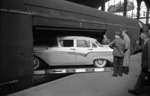 Verladung eines Ford Straßenkreuzers in den Autotransport-Wagen des Autoreisezuges "Komet" (Hamburg-Altona - Hameln - Basel - Chiasso) auf dem Bahnsteig Gleis 5/6 in Hamburg-Altona. (06.1958) <i>Foto: Walter Hollnagel</i>