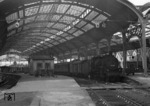 38 3601 wartet mit einem Personenzug nach Köln in der vom Krieg zerstörten "Freilufthalle" des Aachener Hauptbahnhofs. (1950) <i>Foto: Fischer</i>