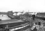 Stimmungsvolles Bild, aufgenommen vom Dach der Güterabfertigung Hamburg Hannov. Bf. Während eine P 8 mit ihrem Personenzug dem Hamburger Hauptbahnhof entgegen strebt, wartet rechts eine pr. T 12 (BR 74) auf den nächsten Einsatz. (20.05.1959) <i>Foto: Walter Hollnagel</i>