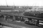 03 092 vom Bw Hamburg-Altona passiert mit einem Eilzug nach Bremen auf der Hamburger Pfeilerbahn zwischen Hauptbahnhof und Abzw. Elbebrücke die dort rangierende 94 1597. (22.05.1959) <i>Foto: Walter Hollnagel</i>