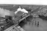 Blick vom Wasserturm auf eine Übergabefahrt mit einer Lok der BR 81, die soeben den Güterbahnhof von Oldenburg verlassen hat, um über die Huntebrücke nach halbrechts den Rangierbahnhof zu erreichen. Ganz rechts die Anschlussgleise zum Hafen und zur Glashütte. (07.05.1954) <i>Foto: Quebe</i>