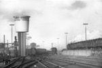 Ein Eilzug mit Doppelbespannung P8 (BR 38.10) passiert auf der Fahrt nach Süden das Bw Hamburg-Altona im seinem markanten neuen Wasserturm. Im Hintergrund ist noch der alte Vorgänger des Wasserturms zu erkennen. (12.12.1955) <i>Foto: Walter Hollnagel</i>