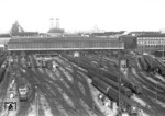 Blick vom Dach des Zentralstellwerks auf den Münchener Hauptbahnhof mit der Frauenkirche. Links rangiert eine E 41, rechts verlässt eine E 16 den Bahnhof.  (01.06.1962) <i>Foto: Walter Hollnagel</i>