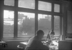 Blick aus der Lokleitung des Bw Altona auf 74 705, die gerade einer der beiden Drehscheiben befährt. Im Hintergund ist der Portaldrehkran der Großbekohlungsanlage zu erkennen. (11.02.1957) <i>Foto: Walter Hollnagel</i>