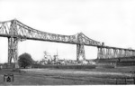 Auf dem Nord-Ostsee-Kanal passiert ein Kriegsschiff der leichten Kreuzerklasse Köln -Leipzig die imposante Stahlkonstruktion der Rendsburger Hochbrücke. (1939) <i>Foto: Walter Hollnagel</i>