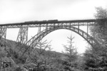 Eine unbekannte 50 überquert mit einem Nahgüterzug die Müngstener Brücke zwischen Solingen und Remscheid. Die 465 m lange Brücke ist auch heute noch mit einer Scheitelhöhe von 107 m die höchste Stahlgitterbrücke Deutschlands. (11.08.1959) <i>Foto: Slg. Eisenbahnstiftung</i>