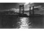 Stimmungsvolle Gegenlichtaufnahme an der Peene mit der Hubbrücke Karnin.Nach der Zerstörung 1945 wurden Bahnverbindung und Brücke nicht mehr aufgebaut, weil ein Teil der Strecke über polnisches Gebiet Usedoms bei Swinemünde (heute Świnoujście) verlief. Die zerstörten Überbauten wurden in den 1950er Jahren entfern. Ein Teil der festen Überbauten wurde verschrottet, der Rest zum Wiederaufbau der Ostbahnbrücke über die Oder in Küstrin verwendet. 1990/91 rettete ein Brückenbau-Ingenieur den Hubbrückenteil vor dem drohenden Abriss. (1933) <i>Foto: RVM</i>