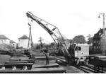 DEMAG-Schienenkran beim Verladen von Blechteilen an einem unbekannten Ort. (1958) <i>Foto: Slg. Eisenbahnstiftung</i>
