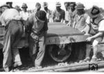 Gleisbaurotte beim Eingleisen eines Kleinwagenanhängers. Auf die heute übliche Schutzkleidung wurde im Sommer 1934 noch keinen Wert gelegt, damals reichte auch die "Krachlederne" aus. (1934) <i>Foto: RVM</i>