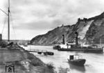 Das Schleppschiff "Köln" liegt in Bad Salzig vor Anker. Im Hintergrund das bekannte Kloster Bornhofen mit den Burgruinen Liebenstein und Sterrenberg, auch bekannt als "die feindlichen Brüder". Davor verläuft die rechtsrheinische Bahnstrecke. (1931) <i>Foto: RVM</i>