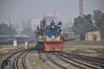Jede Lok und jeder Zug werden genutzt, um eine kostenlose Beförderung zu ergattern. Hier fährt Lok BR 2609 mit einem Personenzug in Dhaka-Kamlapur ein. Gut zu erkennen sind die neu verlegten aber ungenutzten Breitspurgleise für den Verkehr nach Indien. Der dichte gemischte Betrieb auf zwei Spurweiten ist offensichtlich zu kompliziert. Die Breitspurzüge enden deshalb im Vorort-Bahnhof Dhaka-Cantonment. (08.01.2015) <i>Foto: Johannes Glöckner</i>