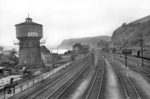 Blick auf die nördliche Bahnhofsausfahrt von Linz am Rhein. Der markante Wasserturm des auf der rechten Seite gelegenen Bahnbetriebswerks ist längst verschwunden. Auf der Drehscheibe wendet eine 94er. (1951) <i>Foto: Fischer</i>