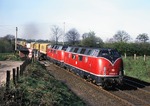 220 048 + 220 025 passieren mit KLV-Zug Ne 62672 den Bahnübergang "Im Seybeck" in Rümpel (südl. Bad Oldesloe). (18.04.1981) <i>Foto: Joachim Bügel</i>