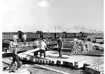 Verladung neuer Schwellen in einem russischen Sägewerk. Im Anschlußgleis warten die Arbeitszüge, die die Schwellen direkt zu den Baustellen bringen. (1942) <i>Foto: RVM (Bandelow)</i>