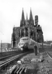 VT 10 551 "Komet" während einer Präsentationsfahrt vor der Kulisse des Kölner Doms. Der rot/silberne VT 10 551 war ein achtteiliger Triebwagenzug (zwei Triebköpfe, sechs Mittelwagen) für den Nachtverkehr der DSG und verkehrte als Ft 49/50 dreimal wöchentlich zwischen Hamburg-Altona und Zürich. (1954) <i>Foto: Fischer</i>