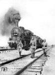 Bahnschutzpolizisten sichern einen Sonderzug mit zwei Lokomotiven der Baureihe 55, irgendwo in der besetzten Sowjetunion. Die führende 55 4160 war vor dem Rußlandeinsatz im Bw Dillenburg stationiert, danach beim Bw Pleskau und Roslawl. (1943) <i>Foto: RVM (Bandelow)</i>