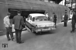 Verladung eines niederländischen Ford Straßenkreuzers in den Autotransport-Wagen des Autoreisezuges "Komet" (Hamburg-Altona - Hameln - Basel - Chiasso) auf dem Bahnsteig Gleis 5/6 in Hamburg-Altona. (06.1958) <i>Foto: Walter Hollnagel</i>