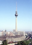 Eine 232 befördert einen Schnellzug über die Berliner Stadtbahn kurz hinter dem Bahnhof Alexanderplatz. Darüber trohnt der Fernsehturm, mit 368 m das höchste Bauwerk Deutschlands. (19.08.1990) <i>Foto: Peter Schiffer</i>
