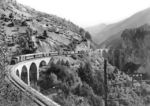 Eine Ge 6/6 der Rhätischen Bahn überquert mit einem GmP das 35 m hohe und 137 m lange Schmittentobelviadukt nahe Filisur. Im Hintergrund das bekannte 65 m hohe Landwasserviadukt, das in einem Kreisbogen direkt in einen Tunnel der gegenüberliegenden Felswand führt. (1928) <i>Foto: RVM-Archiv</i>