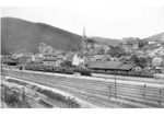 Blick auf den Bahnhof und Ort Altenhundem im Sauerland mit der auf Ausfahrt wartenden 93 1048 vor P 1367, die zum Bw Erndtebrück gehört. Zur Bewältigung des Güterverkehrs über die steigungsreichen Strecken des Sauerlands waren in Altenhundem neben den preußischen Güterzuglokomotiven G 8.1, G 10 und G 12 gleichzeitig bis zu 39 Loks der Baureihe 44 beheimatet. (1931) <i>Foto: DLA Darmstadt</i>