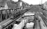 Wiederaufbau der Fernbahngleise über die Wupper  in der östlichen Bahnhofseinfahrt von Wuppertal-Oberbarmen. 01 1074 rollt vor Städteschnellzug S 324 aus Hagen in den Bahnhof ein. Im Hintergrund ist die im Volksmund bekannte "Schwindsuchtsbrücke" zu erkennen, deren Bohlenbretter regelmäßig im Abdampf der ausfahrenden Loks bedrohlich erzitterten. (30.05.1951) <i>Foto: Carl Bellingrodt</i>