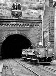 Der Inspektionszug verlässt den Kaiser-Wilhelm-Tunnel am Ostportal in Cochem (vgl. auch Bild-Nr. 49559). Der Tunnel ist 4205 Meter lang und war bis 1988 Deutschlands längster Eisenbahntunnel durch ein natürliches Hindernis. Durch dieses Bauwerk konnte die große Moselschleife am Calmont (von Cochem bis nach Neef) umgangen und die Strecke von 30 Kilometern auf fünf Kilometer verkürzt werden. Erbaut wurde er von 1874 bis 1877. Wie andere herausragende Bauwerke wurde er nach dem Deutschen Kaiser Wilhelm I. benannt. Diesen Namen trägt er offiziell noch heute.  (1931) <i>Foto: RVM</i>