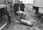 Entfernung des Zünders bei einer Fliegerbombe im Hagener Güterbahnhof. Da bei dieser gefährlichen Arbeit sicherlich keine Zuschauer erlaubt waren, dürfte es sich wohl um ein gestelltes Propagandafoto handeln. (1944) <i>Foto: RVM (Eckler)</i>
