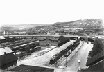 Blick auf Bahnhofsanlagen und Blaubeurertor-Straßenbrücke in Ulm, kurz nach Abschluss der Elektrifizierungsarbeiten. Im Hintergrund ist schwach das Bahnbetriebswerk mit zwei Lokomotiven der Baureihe E 17 zu erkennnen. (1933) <i>Foto: RVM</i>