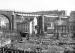 Die parallel verlaufenden Strecken der Bergisch-Märkischen und Rheinischen Strecke waren im Osten Wuppertals miteinander verbunden. Obwohl die beiden Bahnhöfe Wichlinghausen und Barmen-Rittershausen (später Wt-Oberbarmen) nur wenige hundert Meter Luftlinie auseinander lagen, war wegen des Höhenunterschieds zwischen der Talsohle und den Nordhängen eine größere Streckenlänge über Langerfeld erforderlich, wobei das Schwarzbachtal mit dieser Brücke überquert wurde. Ende der 1920er Jahre wurden die alten Brückenüberfahrten durch neue Stahlkonstruktionen ersetzt (vgl. auch Foto-Nr. 4366). (1929) <i>Foto: RVM (Eckler)</i>
