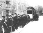 Bei der sog. "Schlacht um Berlin" (16. April - 02. Mai 1945) wurde zum Ende des Zweiten Weltkriegs alles an Material in den Berliner Straßen herangeschafft, was vermeintlich zur Verstärkung von Panzersperren eingesetzt werden konnte, wie dieser Straßenbahnwagen der BVG in Schöneberg. Nach Ende der Kampfhandlungen wird der unzerstörte Straßenwagen per Muskelkraft aus dem stromlosen Abschnitt Schöneberger Akazienstr. / Ecke Apostel-Paulus-Str. Im Hintergrund ist die Apostel-Paulus-Kirche an der Ecke Grunewaldstr. und Akazienstr. zu erkennen. (24.06.1945) <i>Foto: Pressefoto ACME</i>
