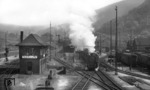Blick auf die Gleisanlagen und Weichenstraßen des alten Heidelberger Hauptbahnhof, den gerade 50 1925 mit einem Eilzug verlässt. Der erste Bahnhof entstand 1840 als Kopfbahnhof nahe der Heidelberger Altstadt. Städtebauliche Probleme durch den teilweisen Ausbau zum Durchgangsbahnhof 1862 und fehlende Erweiterungsmöglichkeiten führten Anfang des 20. Jahrhunderts zu der Entscheidung, den Bahnhof um gut einen Kilometer nach Westen zu verlegen und dort als Durchgangsbahnhof neu zu bauen. Unterbrochen von beiden Weltkriegen dauerte die Verlegung der Heidelberger Bahnanlagen über 50 Jahre. Der neue Durchgangsbahnhof wurde am 5. Mai 1955 eingeweiht. (14.09.1952) <i>Foto: Walter Hollnagel</i>