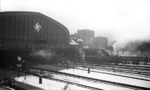 Blick auf den Hamburger Hauptbahnhof im Winter 1936.Anläßlich einer Versuchsfahrt steht im Hintergrund schemenhaft zu erkennen die bordeauxrote 05 002 vor der Halle. (27.02.1936) <i>Foto: Walter Hollnagel</i>