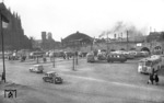 Blick auf den alten Kölner Busbahnhof am Hauptbahnhof, dessen Halle und Türme des Vorkriegs-Empfangsgebäudes im Hintergrund erkennbar sind. Heute befindet sich hier das Museum Ludwig. Im Hauptbahnhof dampft eine 03.10 vor sich hin. (04.1952) <i>Foto: Fischer</i>
