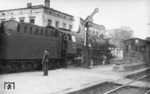 01 1080 (Bw Hagen-Eckesey) verlässt vor D 65 den Bahnhof Wuppertal-Oberbarmen, dessen Empfangsgebäude von Kriegsschäden noch stark gezeichnet ist. Die Stellwerksbezeichnung "R" des am Bahnsteig stehenden Behelfsstellwerk weist auf die alte Stadtteilbezeichnung von Oberbarmen hin, das früher "Rittershausen" hieß. (18.05.1949) <i>Foto: Carl Bellingrodt</i>