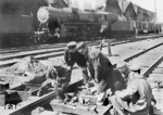 Reparatur einer Handweiche im Bahnhof Snamenka. Im Hintergrund eine 52er mit Steifrahmentender, bei dem alle vier Achsen in einem Außenrahmen lagerten. Diese Tender waren eine Entwicklung der Lokomotivfabrik Floridsdorf in Wien. (1943) <i>Foto: Walter Hollnagel</i>