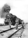 Bahnschutzpolizisten sichern einen Sonderzug mit zwei Lokomotiven der Baureihe 55, irgendwo in der besetzten Sowjetunion. Die führende 55 4160 war vor dem Rußlandeinsatz im Bw Dillenburg stationiert, danach beim Bw Pleskau und Roslawl. (1943) Foto: RVM (Bandelow) (1943) <i>Foto: RVM (Bandelow)</i>