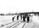 Dienstverpflichtete einheimische Männer und Frauen versuchen eine Weichenverbindung im Bahnhof Minsk vom Schnee zu befreien. (1942) <i>Foto: RVM (Bandelow)</i>