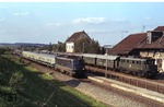 110 297 überholt vor D 385 (Stuttgart - Neapel) einen Personenzug mit 144 043 im Bahnhof Bondorf (zwischen Herrenberg und Eutingen).  (11.05.1978) <i>Foto: Peter Schiffer</i>