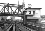 Befehlsstellwerk "Abf" am Anhalter Bahnhof in Berlin. Der Blick führt vom Gelände des Anhalter Güterbahnhof unter der prunkvoll verzierten Hochbahnbrücke hindurch zur großen Fernbahnhalle. Das Stellwerk "Abf" wurde im Jahr 1927 vom Reichsbahnarchitekten Richard Brademann entworfen, der auch für viele andere Hochbauten der Berliner S-Bahn verantwortlich war. An dieser Stelle werden die vier Bahngleise über den Landwehrkanal geführt. Seit 1939 verläuft unter dem Landwehrkanal sogar der Tunnel der Nord-Süd-S-Bahn. Heute befindet sich in der Achse der ehemaligen Fernbahnbrücke eine Fußgängerbrücke.  (1932) <i>Foto: RVM</i>
