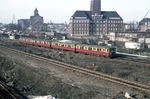 Ein Halbzug der Bauart "Stadtbahn" vor der Kulisse des "Berliner Westhafens" (BEHALA – Berliner Hafen-und Lagerhausgesellschafts mbH). Er kommt von der Station "Beuselstrasse" und wird gleich in die Station "Westhafen" einfahren (heutige Linie „Ring 41"). (04.04.1979) <i>Foto: Peter Schiffer</i>