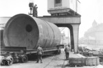 Schwertransporte auf der Straße wickelte die Deutsche Reichsbahn über die Culemeyer Straßenroller-Fahrzeuge ab, wie hier die Anlieferung eines Tankbehälters im Berliner Westhafen. Das Gebäude hinter dem Kran mit dem Turm ist das heute noch vorhandene Verwaltungsgebäude der BEHALA Westhafen. Bei dem rechts im Dunst erkennbaren Speichergebäude (rechts) ist die charakteristische Brücke für die Saugentladung auszumachen. (1937) <i>Foto: RVM</i>