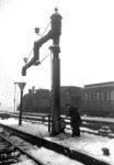 Um die Wasserkräne vor Frost zu schützen, wurden diese in Köln Hbf mit angebauten Öfen erwärmt. Hier versorgt ein Eisenbahnner am Gleis 5/6 den Kran mit neuem Brennstoff und hat bereits einen beachtlichen Aschehaufen entsorgt. Im Hintergrund wartet eine 78er auf die Ausfahrt nach Deutz. (1955) <i>Foto: Fischer</i>