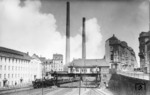 18 311 läuft vor E 112 nach Koblenz in den Bahnhof Wuppertal-Barmen ein. Die 134 und 100 m hohen Kamine gehören zum Heizkraftwerk Barmen. (21.05.1936) <i>Foto: RVM-Filmstelle Berlin</i>