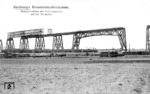 Bau der Rendsburger Hochbrücke über den Nord-Ostsee-Kanal. Für die Brücke wurden 17740 t Stahl mit 3,2 Millionen Nieten zusammengefügt. Der Bau kostete 13,4 Millionen Mark. Unten fährt ein Personenzug mit einer pr. P 4.2 (Baureihe 36) an der Baustelle vorbei. (1912) <i>Foto: RVM-Archiv</i>