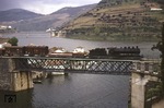 Lok 74051 der Portugisischen Eisenbahn überquert mit einem Güterzug die Brücke über den Douro bei Pinhão, im Zentrum des Portwein-Anbaugebietes im Norden Portugals. (20.04.1974) <i>Foto: Colin Brack</i>